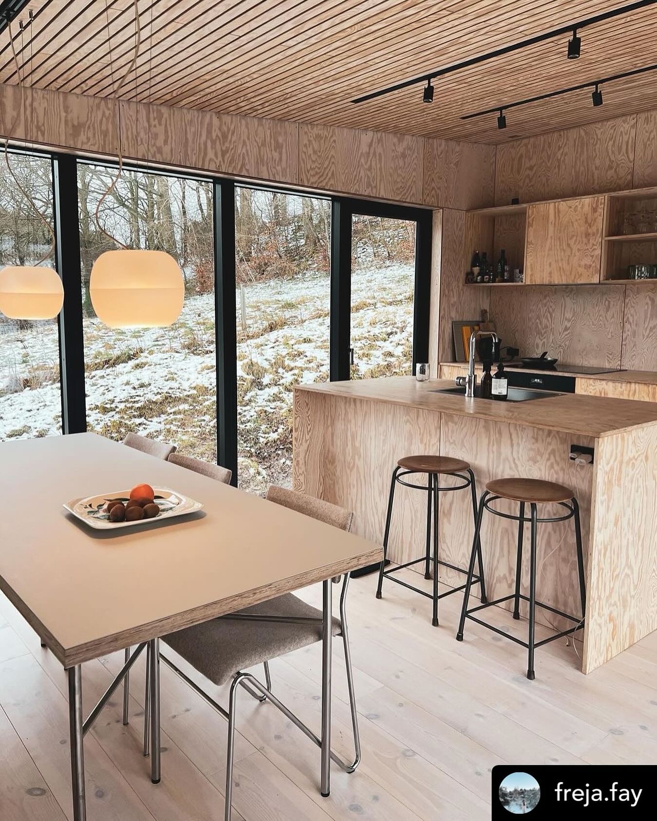 Plywoodkøkken med store vinduer og barstole